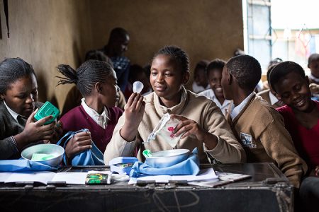 Schülerinnen mit dem erhaltenen Ruby Cup Menstruationstassen Set, Ufasini Schule im Kayole Slum in Nairobi, Schülerinnen erhalten einen Workshop von Femme International Mitarbeiterinnen, die ihnen Menstruationstassen von Ruby Cup erklären und verteilen, die Mitarbeiterinnen sind selbst im Slum aufgewachsen und arbeiten ehrenamtlich, Menstruationshygiene in Kenia